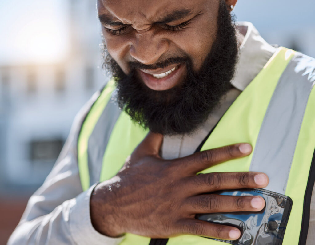 Stress, construction worker and a black man with a heart attack in the city. Healthcare, burnout and an African builder, architect or handyman with anxiety, chest pain or medical emergency on site.