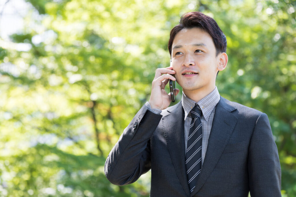 asian businessman using smart phone in park