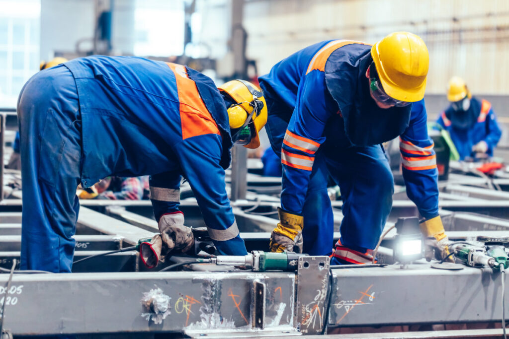 Blue-collar workers at work in a big factory. Heavy industry, labor in shipyard