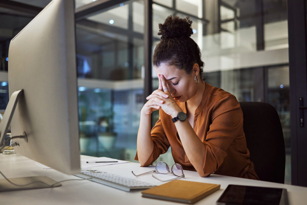 Headache, business woman at night and computer stress while working for a deadline with pc glitch. Sad corporate manager with anxiety about target working at desk screen late to complete task online.